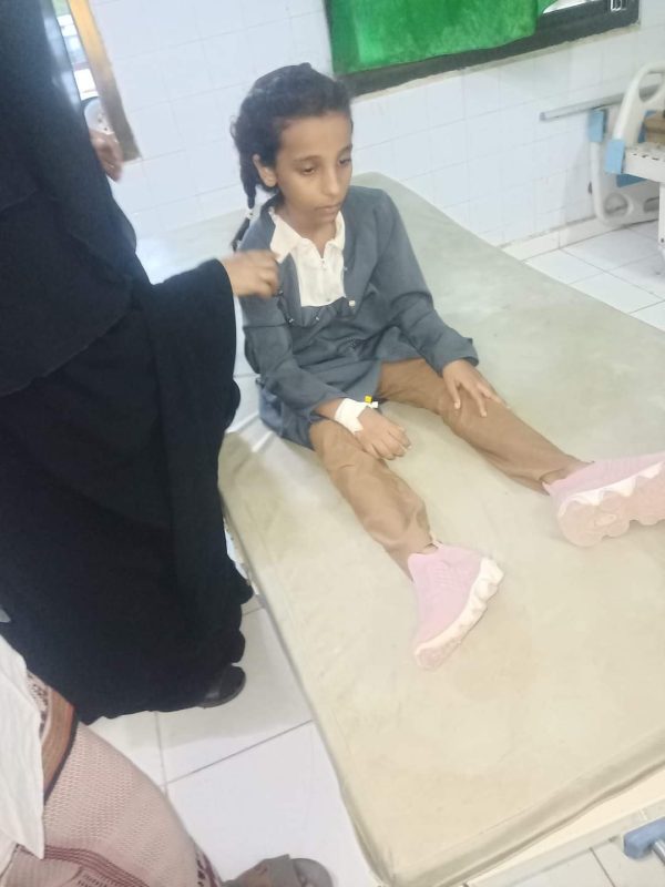 إحدى الطالبات المغمى عليهن وهي تتلقى الرعاية الصحية. 